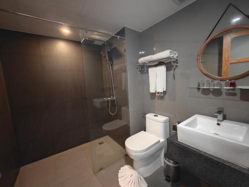 uma casa de banho com um WC, um lavatório e um chuveiro em Phang Nga Shore Hotel em Khao Lak