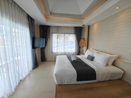 Phang Nga Shore Hotel في خاو لاك: غرفة نوم بسرير كبير ونافذة كبيرة