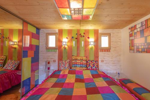 a bedroom with a colorful bed in a room with windows at La Bella Vista in Curel
