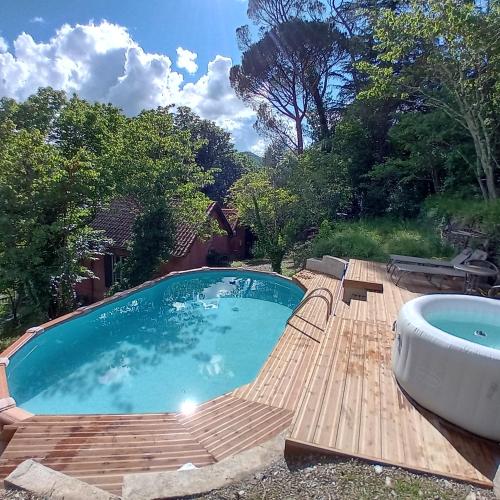 une piscine avec baignoire sur une terrasse en bois dans l'établissement Mas Dupoune avec Piscine & Spa, à Sumène