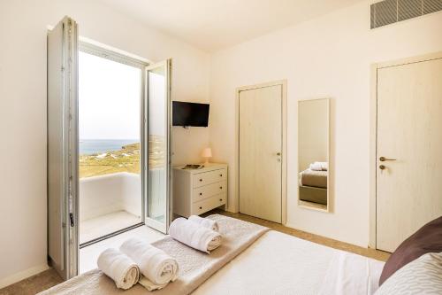 a bedroom with a tub and a bedroom with a window at Cabana Seaview Pool Villas w Night Security Guard, near Alemagou beach in Elia