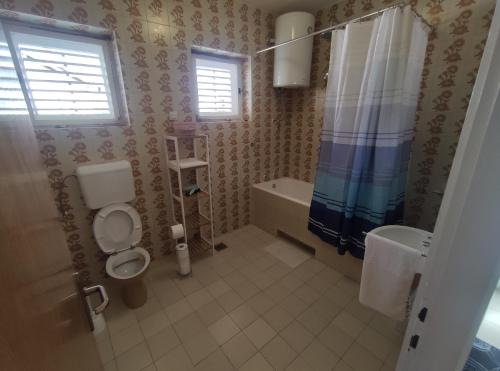 y baño con aseo, bañera y lavamanos. en Apartment Landeka en Primošten