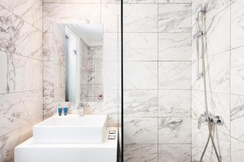 a white bathroom with a sink and a shower at Cameo Beach Resort in Laganas