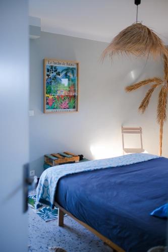 - une chambre avec un lit bleu et un palmier dans l'établissement Villa d'exception vue mer avec piscine privée, à Saint-Raphaël
