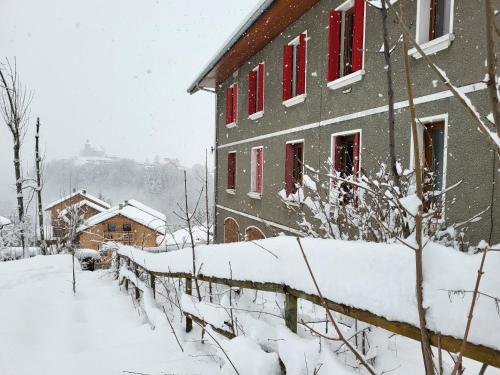 a building covered in snow with red windows at Le reposoir in Mont-Saxonnex