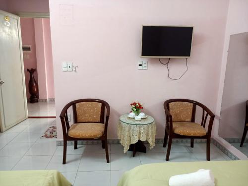 um quarto com duas cadeiras e uma mesa com uma televisão em Motel Tulip em Da Nang