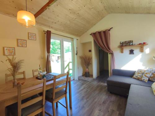 een woonkamer met een tafel en een bank bij Tinyfarm "Stará Láska" - Holidayfarm Natural Slovakia in Modrý Kameň
