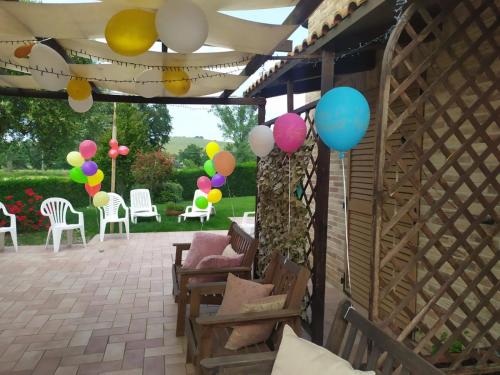a patio with balloons and chairs and a pergola at Cascina del Poeta in Recanati