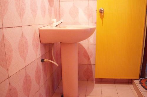 ミリッサにあるSagopearl Guestの黄色のドア付きのバスルーム(白い洗面台付)