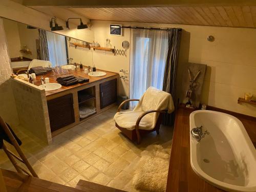 une salle de bain avec deux lavabos et une baignoire dans l'établissement Maison avec piscine, à Soumensac