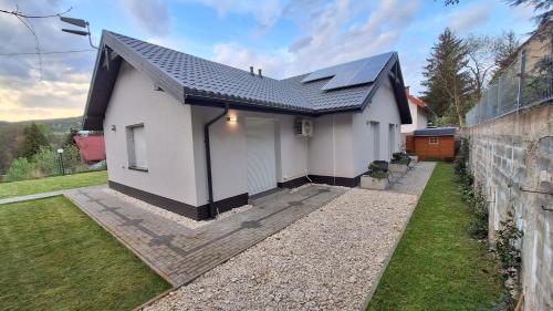 a white house with a black roof at Pensjonat Na Każdą Porę in Lądek-Zdrój