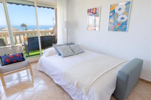 een wit bed in een kamer met uitzicht op de oceaan bij Sea Soul by Fidalsa in El Campello
