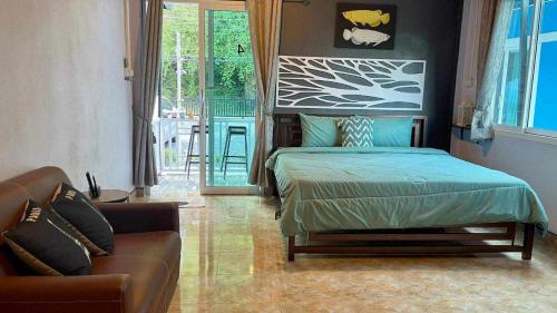- une chambre avec un lit et un canapé dans l'établissement Khao thalu guest house, à Ban Muang Wan