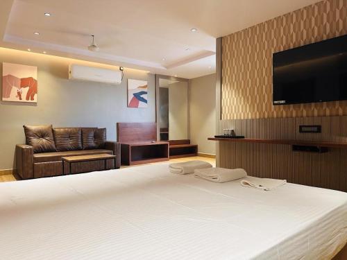 a hotel room with a bed and a flat screen tv at V HOTEL in Brahmapur