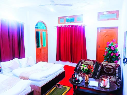 a room with two beds and red curtains at Hotel Prakriti Darshan in Bhatwāri