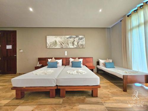 a bedroom with two beds with blue pillows at Oak Ray Regency in Kandy