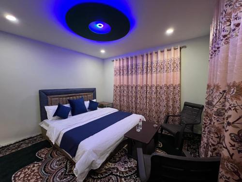 a bedroom with a bed with a blue light on the ceiling at GUREZ GUEST HOUSE in Kanzalwan