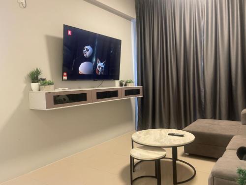 a living room with a flat screen tv on a wall at IPOH TAMBUN THE COVE Your Ultimate Relaxation Getaway777 -3 BED ROOM -NO PETS ALLOW in Ipoh