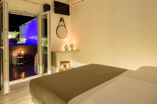 a bedroom with a bed and a room with a table at Athiri Luxury Suites in Perivolos