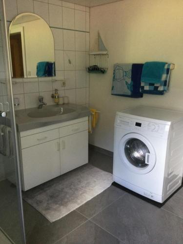 a bathroom with a washing machine and a sink at Familie Seiwald in Waidring