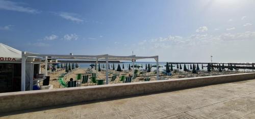 una fila di sedie e ombrelloni in spiaggia di Sunset Village a Marina di Montenero