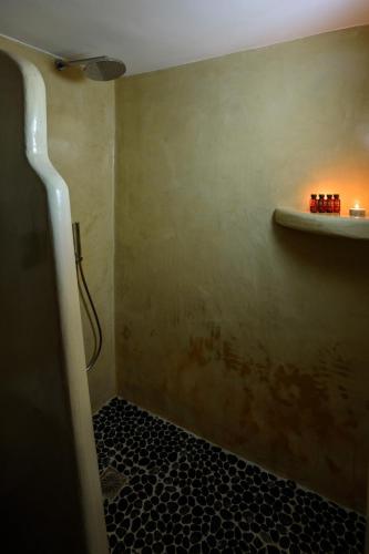 a bathroom with a shower with a black tile floor at Athiri Luxury Suites in Perivolos
