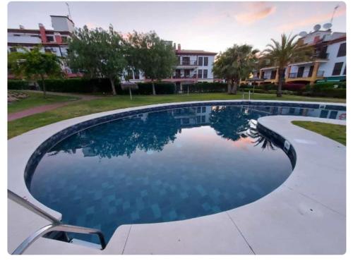 a large swimming pool in front of a building at Esuri Relax & Golf in Ayamonte