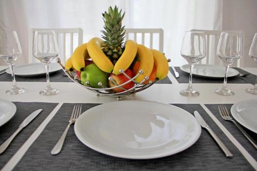 a bowl of fruit on a table with plates and glasses at Villa Dana in Ixia