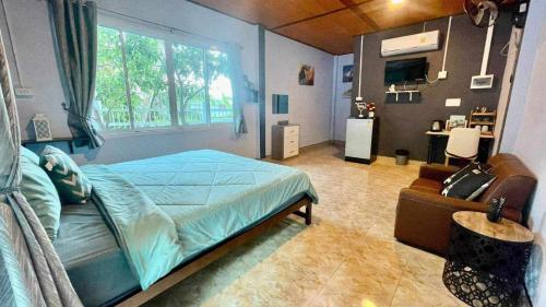- une chambre avec un grand lit et une fenêtre dans l'établissement Khao thalu guest house, à Ban Muang Wan