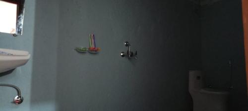 a bathroom with a white toilet and a sink at Hotel Prakriti Darshan in Bhatwāri
