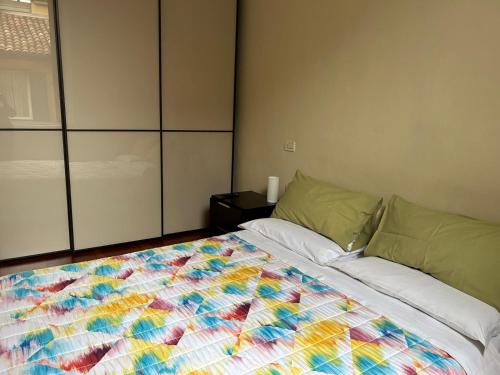 a bedroom with a bed with a colorful quilt on it at Masc 26 in Bologna