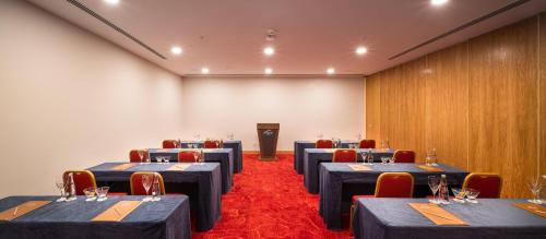 a conference room with blue tables and chairs and a podium at Concorde Tower Hotel & Casino in North Nicosia