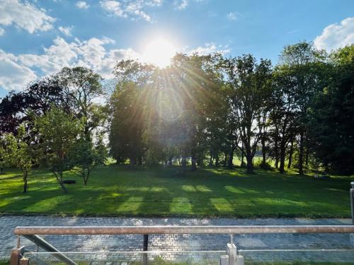 a park with the sun shining through the trees at Gutshaus Wohnung 3 in Laschendorf