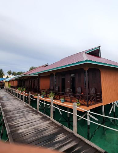 a building on a pier next to the water at Miranda Cottage in Derawan Islands