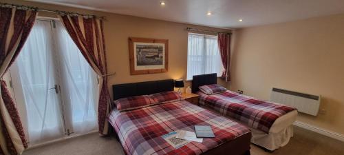 a hotel room with two beds and a window at Town House B & B in Skipton