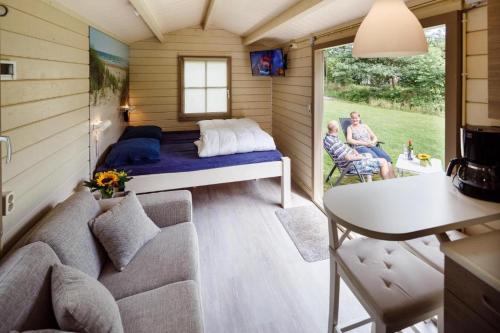 ein kleines Zimmer mit einem Bett und einem Sofa in der Unterkunft RCN Vakantiepark de Roggeberg in Appelscha