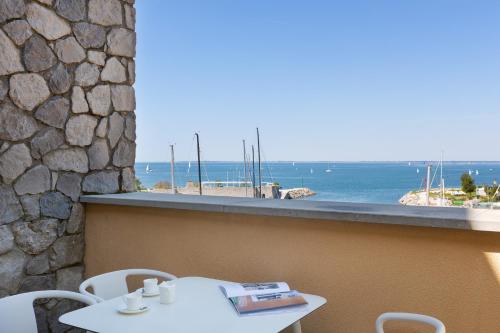 a table and chairs on a balcony with a view of the ocean at Portopiccolo Apartments in Sistiana