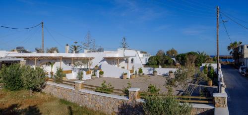 a white house with a yard with cactus at Athiri Luxury Suites in Perivolos