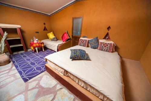 1 dormitorio con 2 camas y 1 litera en Les voix de Sahara Lodge, en Mhamid