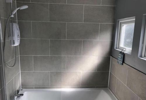 a bathroom with a shower and a bath tub at Cosy Cabin - Bideford Bay Holiday Park in Bideford