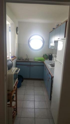 una pequeña cocina con fregadero y ventana en Résidence de la Baie : Superbe appartement en Le Marin