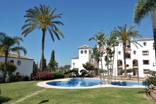 een huis met palmbomen en een zwembad bij Apartamento en Marbella Paraíso al Mar in Marbella