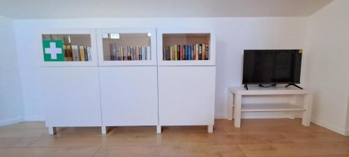 a living room with a tv and a table with a television at A 2 Passi Appartamento in Foligno