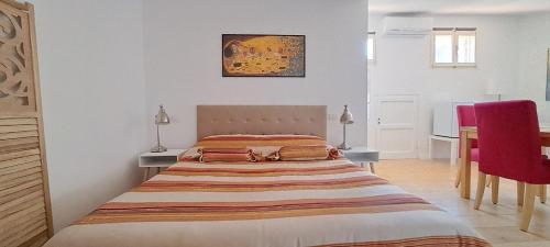 a bedroom with a bed and a table with a red chair at A 2 Passi Appartamento in Foligno