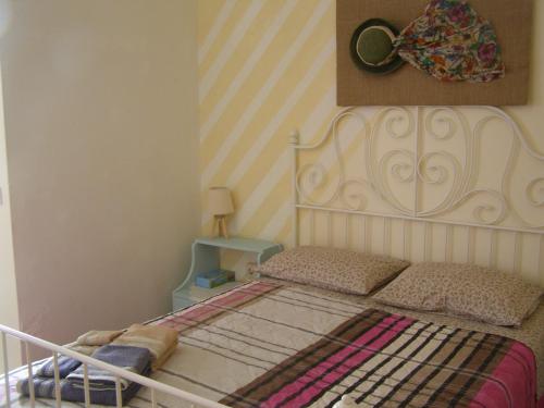 a bedroom with a bed with a white headboard at Doll house next to the sea in Agioi Theodoroi