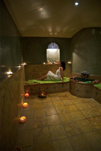 a woman sitting on a bed in a room at Riad Dar L'Oussia & SPA in Essaouira