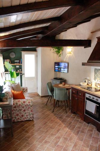 a kitchen and living room with a couch and a table at La casina di mezzo - Tiny House in Camaiore