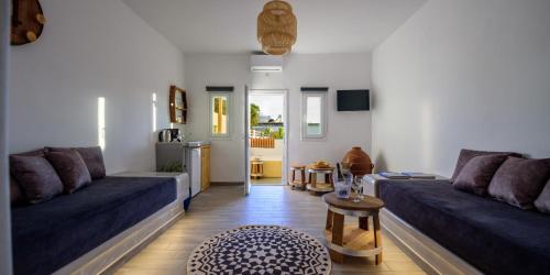 a living room with two blue couches and a table at Athiri Luxury Suites in Perivolos