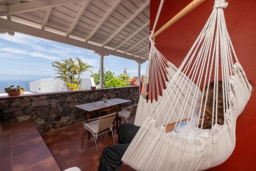 a hammock on a patio with a table at Casa El Drago 1 in Breña Baja