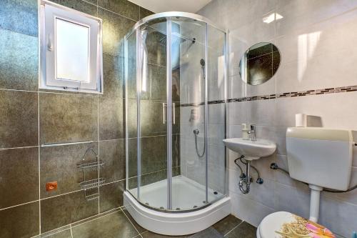 a bathroom with a shower and a toilet and a sink at EDEN Sea View rooms in Mali Lošinj
